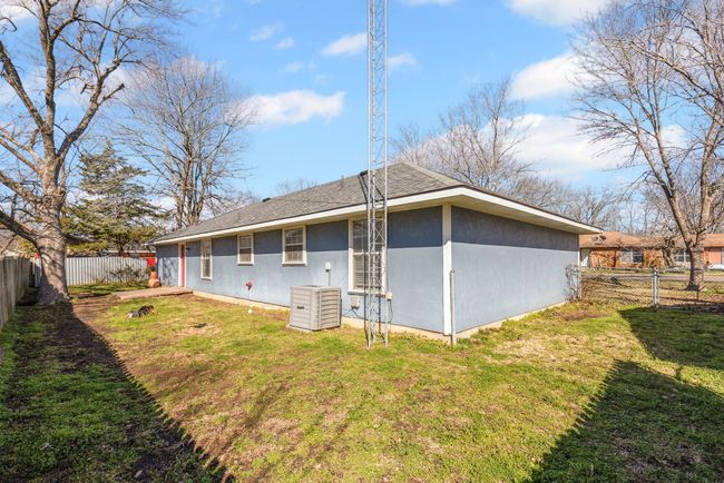 Back of house with siding, a fenced backyard, roof with shingles, and a yard | Image 25