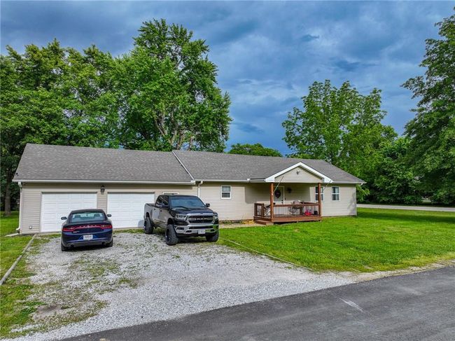Single story home with a front lawn, gravel driveway, an attached garage, and a wooden deck | Image 47