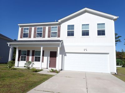 View of front facade featuring a front yard and a garage | Image 1