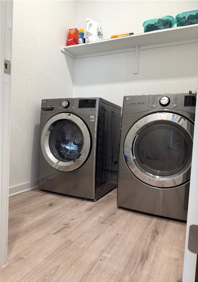 Laundry room featuring washer and clothes dryer, light wood-style flooring, and baseboards | Image 22