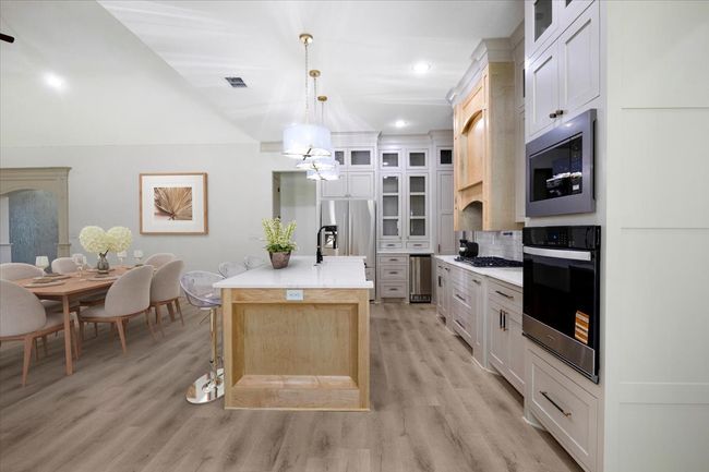 Kitchen with glass insert cabinets, stainless steel appliances, light brown cabinets, pendant lighting, and recessed lighting | Image 29