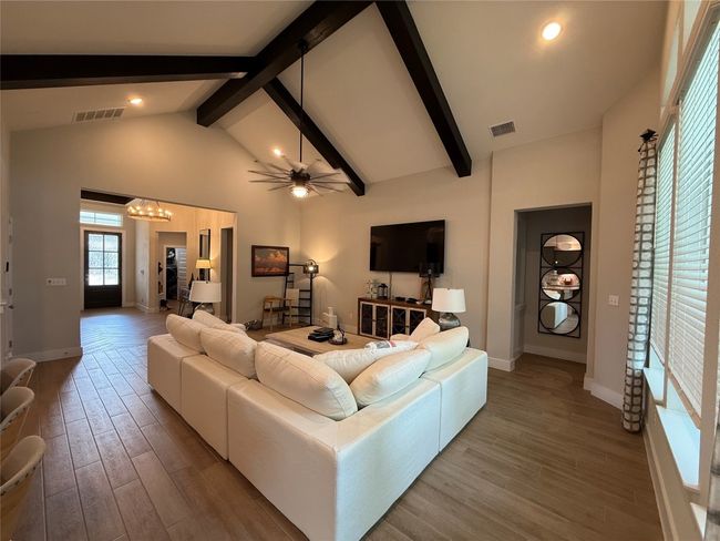 Living area featuring beam ceiling, wood finished floors, baseboards, high vaulted ceiling, and a chandelier | Image 12