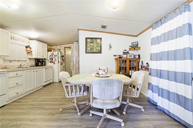Dining area featuring vaulted ceiling . | Image 7