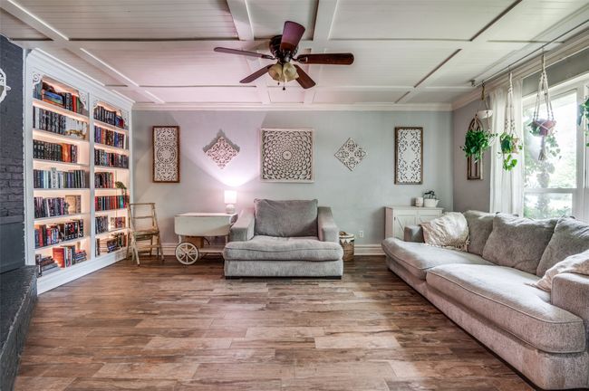 Living room featuring a ceiling fan, wood finished floors, beamed ceiling, built in features, and crown molding | Image 5