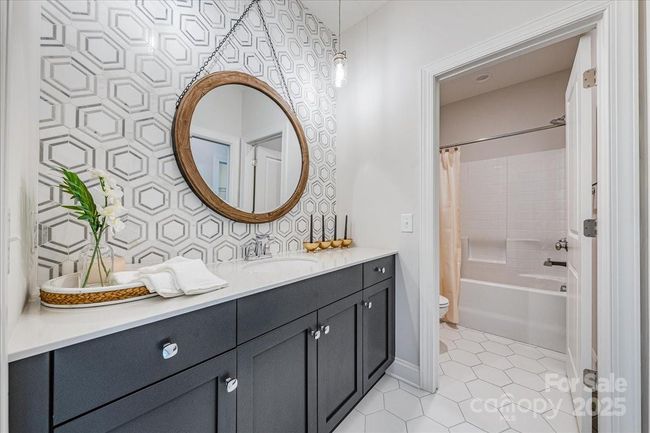 Guest bathroom with private tub/shower combo and custom tile backsplash to add a fun pop of cozy color | Image 25