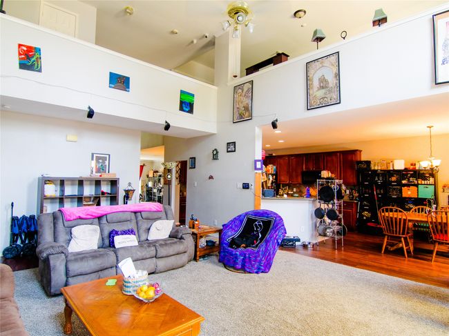 Living room with a chandelier, a towering ceiling, and wood finished floors | Image 5