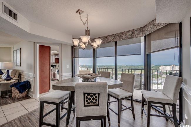 Dining room featuring a textured ceiling, a notable chandelier, and hardwood / wood-style flooring | Image 12