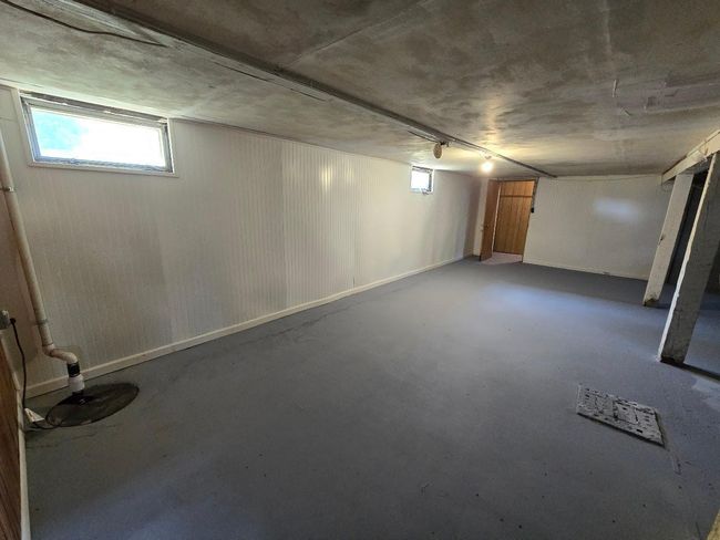 Basement is partially finished with white wainescoting on the walls and painted floors | Image 25