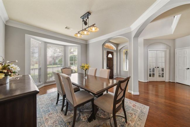 A bay of windows with blinds offer views of the front yard and fills this dining area with plenty of natural light. | Image 6