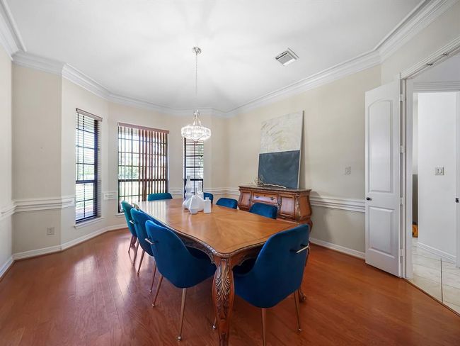 Elegant dining room with classic charm, featuring hardwood floors and a sparkling chandelier—perfect for hosting memorable gatherings. | Image 10