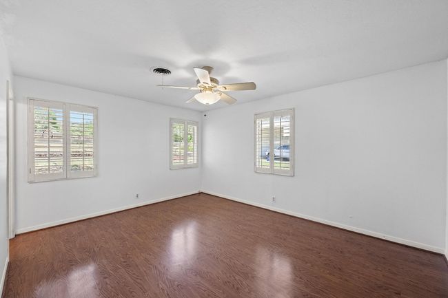 Bedroom featuring dark wood finished floors, a ceiling fan, and baseboards | Image 16