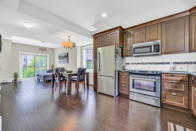 Kitchen featuring stainless steel appliances, a chandelier, tasteful backsplash, light countertops, and recessed lighting | Image 8