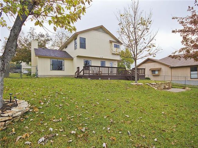 Rear view of property with a deck, a chimney, and a yard | Image 11