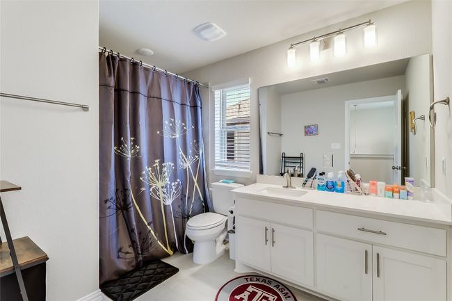 Bathroom featuring vanity, toilet, and curtained shower | Image 32