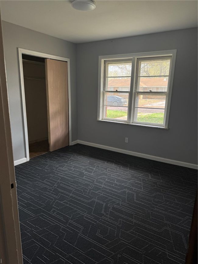 Unfurnished bedroom featuring baseboards, a closet, multiple windows, and dark carpet | Image 13