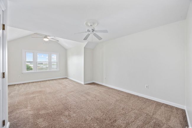 Additional living space featuring a ceiling fan, carpet flooring, baseboards, and vaulted ceiling | Image 23