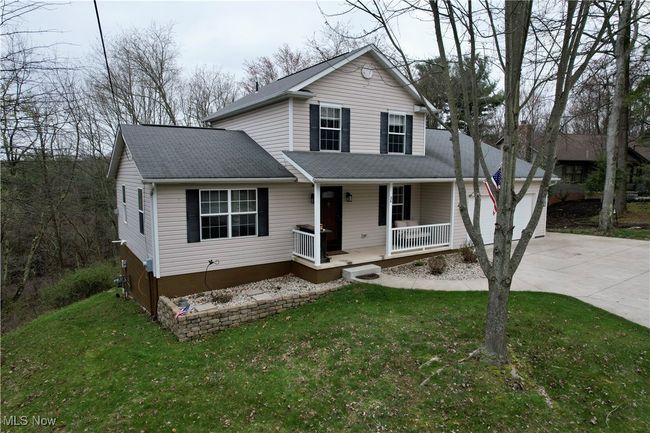 View of front of home with covered porch, driveway, roof with shingles, a front yard, and a garage | Image 49