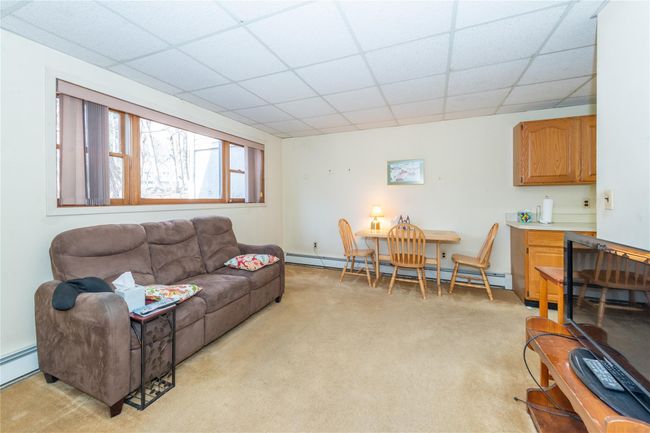 Living room featuring a paneled ceiling, a baseboard radiator, and light colored carpet | Image 31