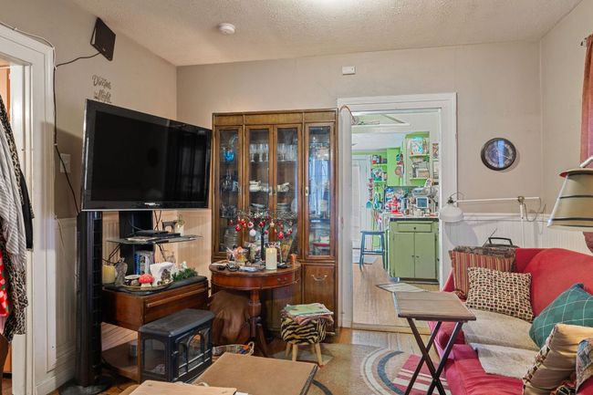 Living room with a textured ceiling and wood finished floors | Image 13