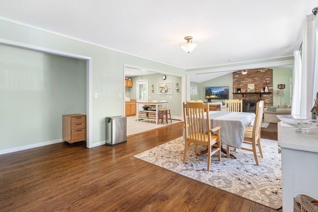 Dining area featuring wood-type flooring, a fireplace, and baseboards | Image 13