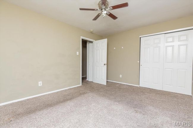 Unfurnished bedroom with carpet floors, a closet, and a ceiling fan | Image 13