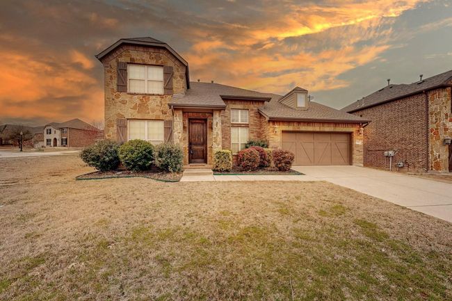 View of front of home featuring stone siding, an attached garage, a front lawn, driveway, and roof with shingles | Image 13