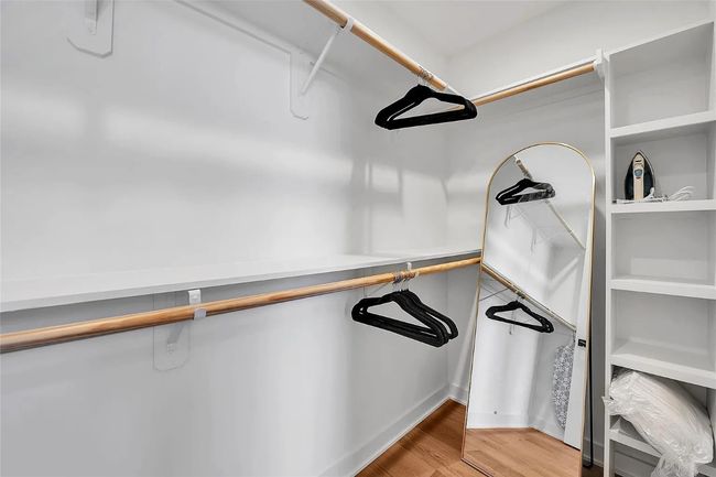 Spacious closet with light wood-type flooring | Image 15