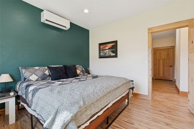 Bedroom with an AC wall unit, baseboards, light wood finished floors, and recessed lighting | Image 12