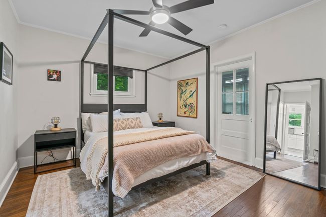 Bedroom featuring multiple windows, dark wood-style floors, ornamental molding, and a ceiling fan | Image 5