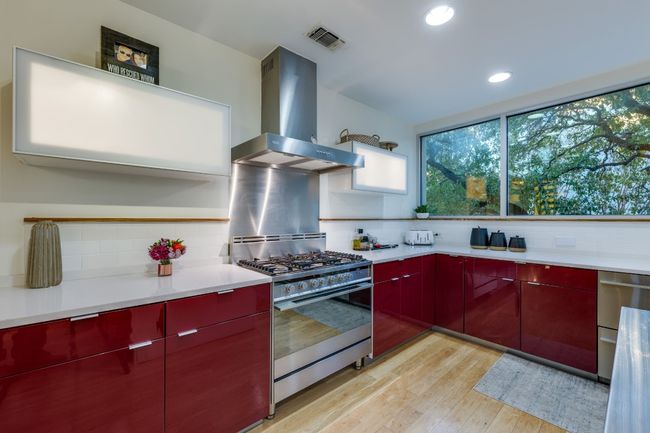 Kitchen with stainless steel range with gas stovetop, light hardwood / wood-style floors, extractor fan, and backsplash | Image 13