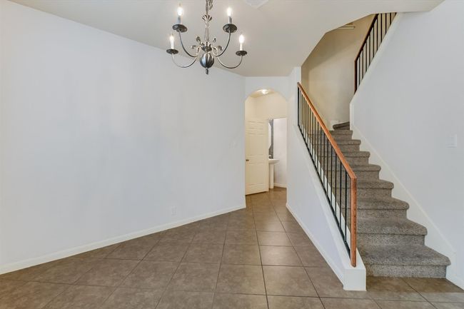 Stairway featuring arched walkways, tile patterned floors, and a chandelier | Image 8
