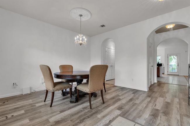 Formal dining area, archway to the left leads into the kitchen, hallway to your right into the living room, half-bath is in the hallway to the left | Image 4
