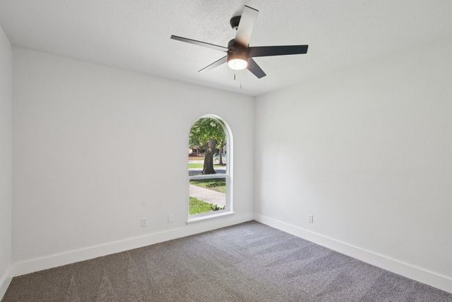 Carpeted empty room with a ceiling fan and baseboards | Image 31