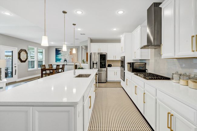 Kitchen features cabinets with hardware and decorative tile backsplash. | Image 14