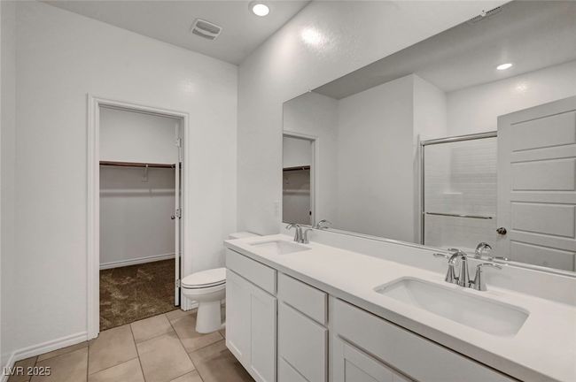 Full bath with a spacious closet, a shower with shower door, toilet, and a sink | Image 34