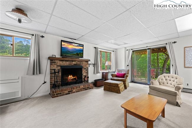 Lower level den with wood burning fireplace. | Image 23