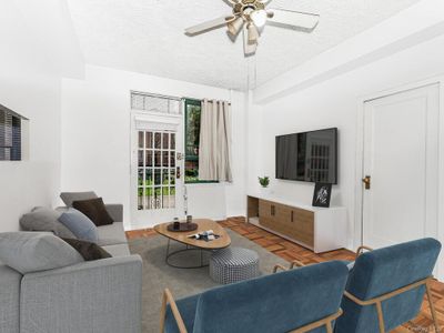 Living room featuring ceiling fan, parquet flooring, and a textured ceiling | Image 2