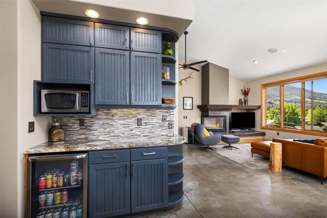 Kitchen with open shelves, open floor plan, stainless steel appliances, concrete floors, and backsplash | Image 7