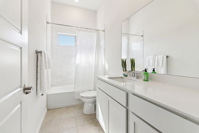 Bathroom with toilet, tile patterned floors, shower / tub combo with curtain, and vanity | Image 20