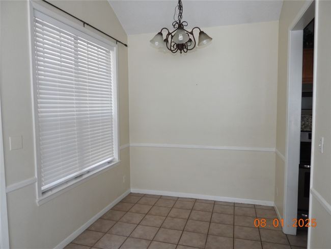 Unfurnished dining area featuring a chandelier and light tile patterned floors | Image 8