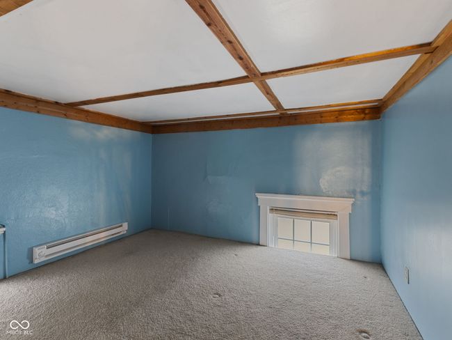 additional living space featuring a baseboard radiator, beam ceiling, and carpet | Image 24