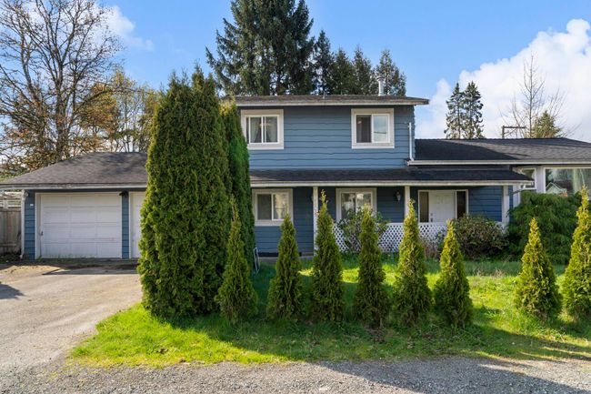 Traditional home featuring driveway and roof with shingles | Image 4
