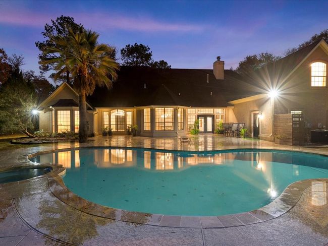 Another twilight view of the pool and patio showcases the home’s beautiful architecture and serene ambiance. | Image 38
