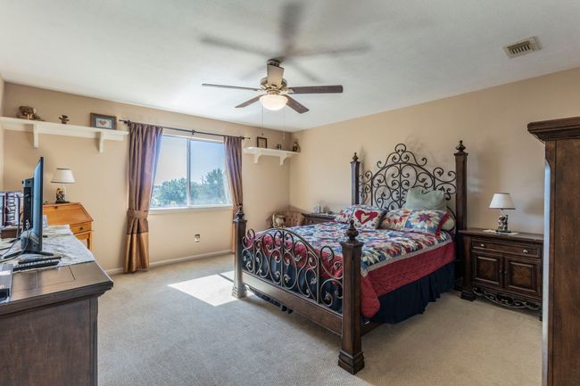 Bedroom with light carpet, ceiling fan, and baseboards | Image 19