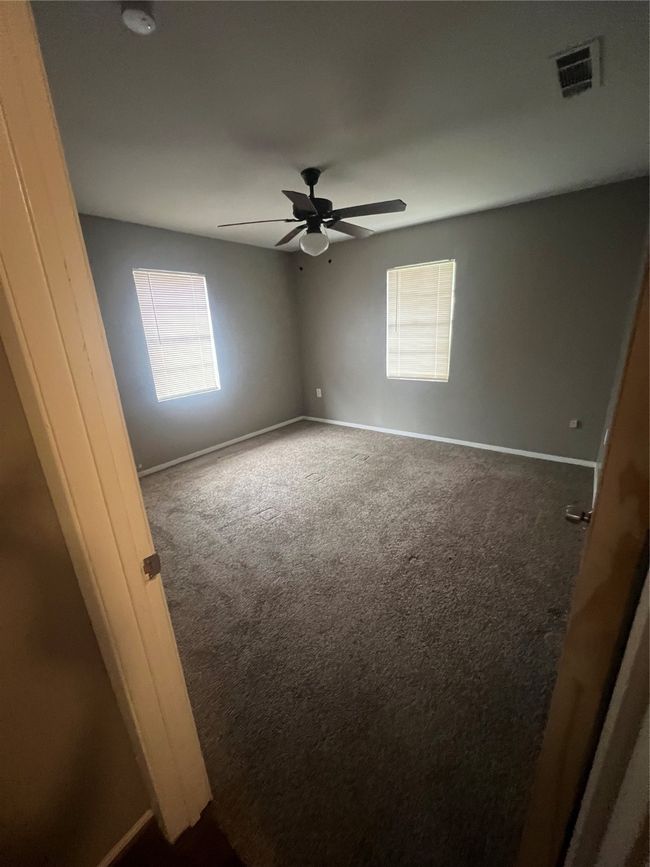 Carpeted empty room featuring baseboards and a ceiling fan | Image 8