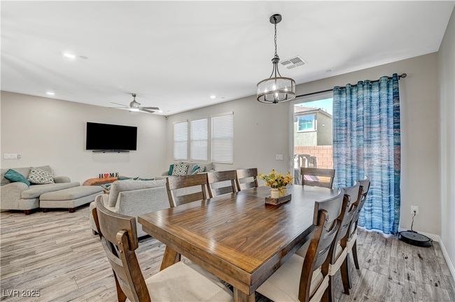 Dining room with light wood-style floors, a chandelier, ceiling fan, recessed lighting, and baseboards | Image 17