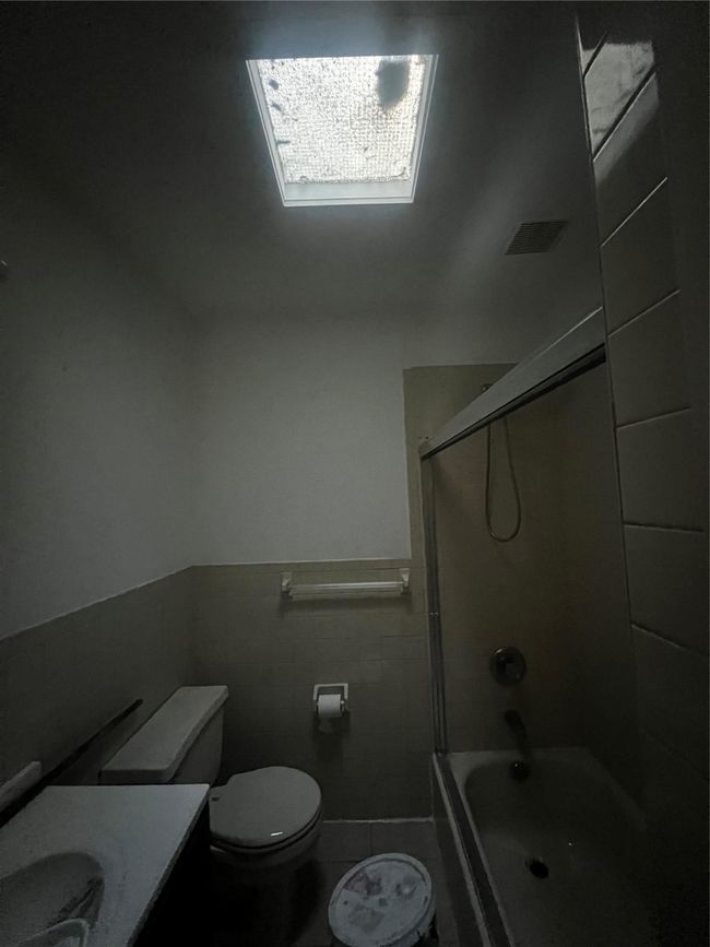Full bath with toilet, vanity, shower / bath combination, tile walls, and tile patterned flooring | Image 7