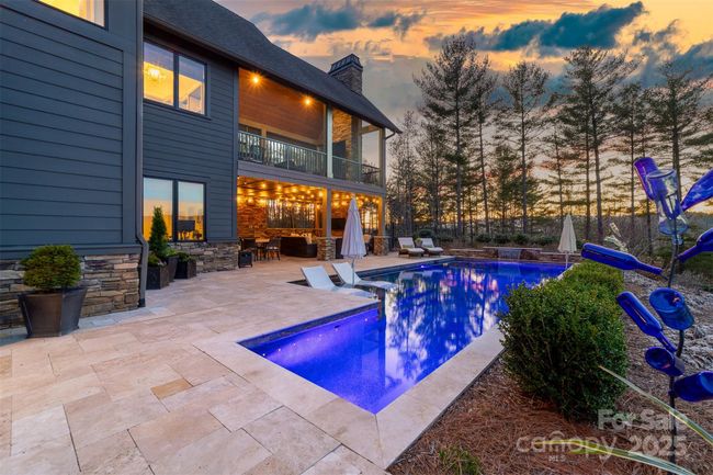 The tasteful patio and pool area blend into the woodland landscaping. | Image 28