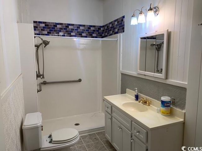 Full bath featuring a shower stall, toilet, vanity, and tile patterned floors | Image 9