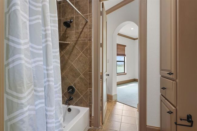 This photo shows the rest of the Jack and Jill bathroom for bedrooms #3 & 4. Built-in cabinetry offering extra storage space. Bedroom #4 through the arch doorway which offers a view of the lake. All bedrooms offer large walkin closets. | Image 44